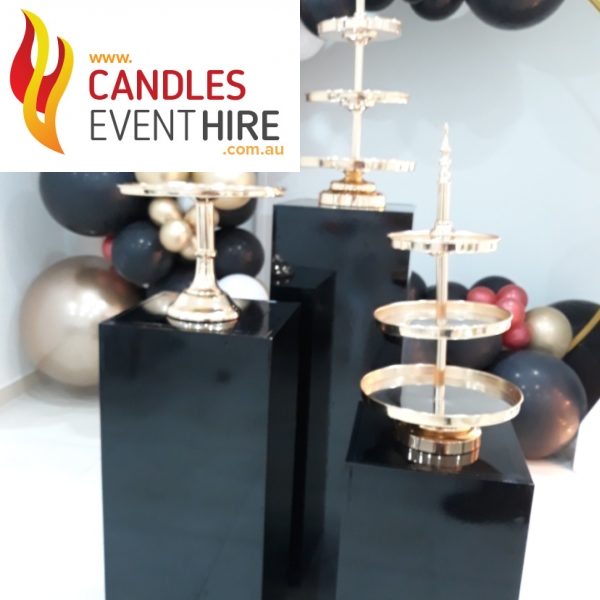 Gold cake stands on black plinths