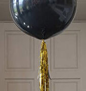 black jumbo balloon with gold tassel